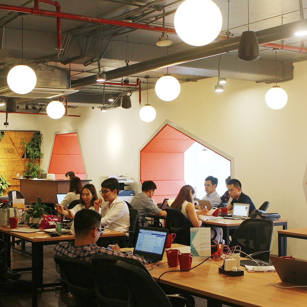 Profesionales trabajando en mesas compartidas de un coworking